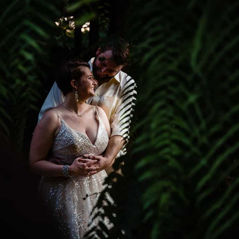 bride and groom between palm fronds in Bali