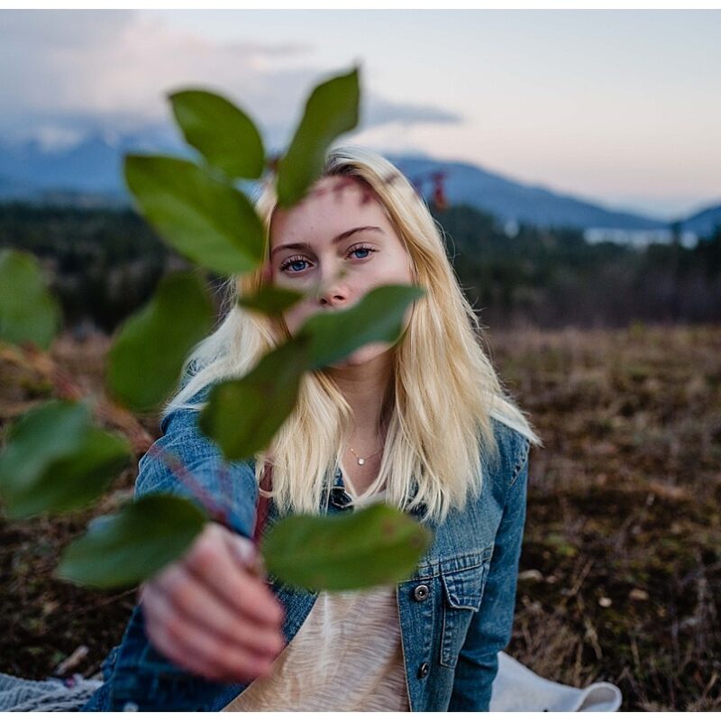 Ashley in a mountain adventure story holding salal