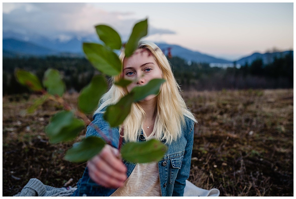 Ashley in a mountain adventure story holding salal