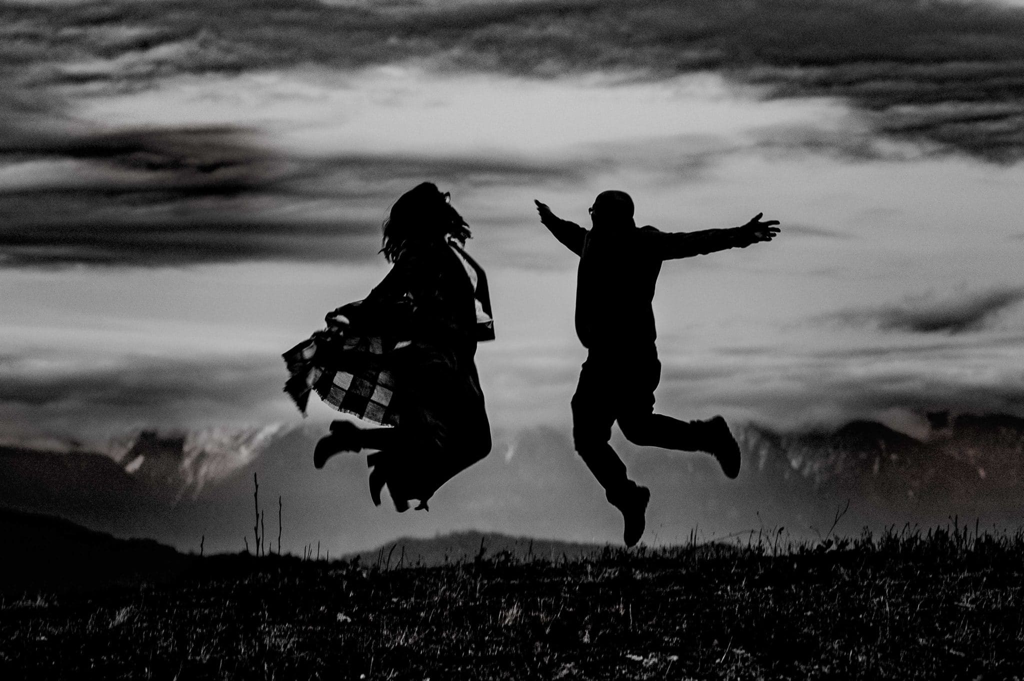 couple jumping in the mountains in lansdale engagement photo