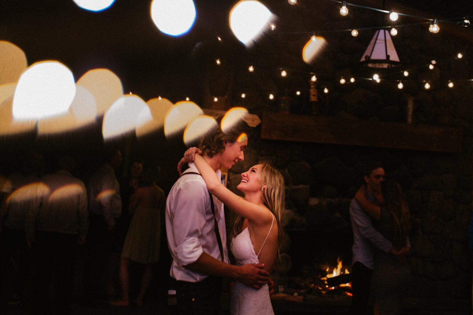 a sunshine coast bc wedding photographed by fresh air photography with a bride and groom dancing in a dark outdoor venue with lights strung up everywhere.