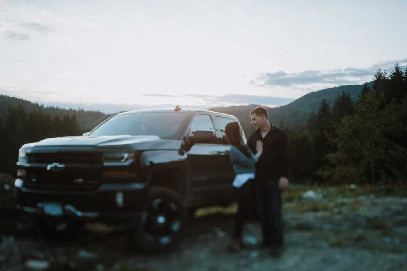 young couple hug by his truck and watch sunset Sunshine Coast BC