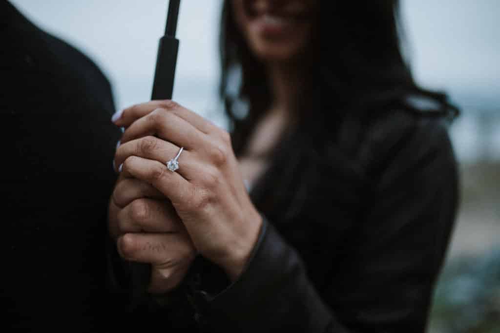 young couple engagement session and showing her ring