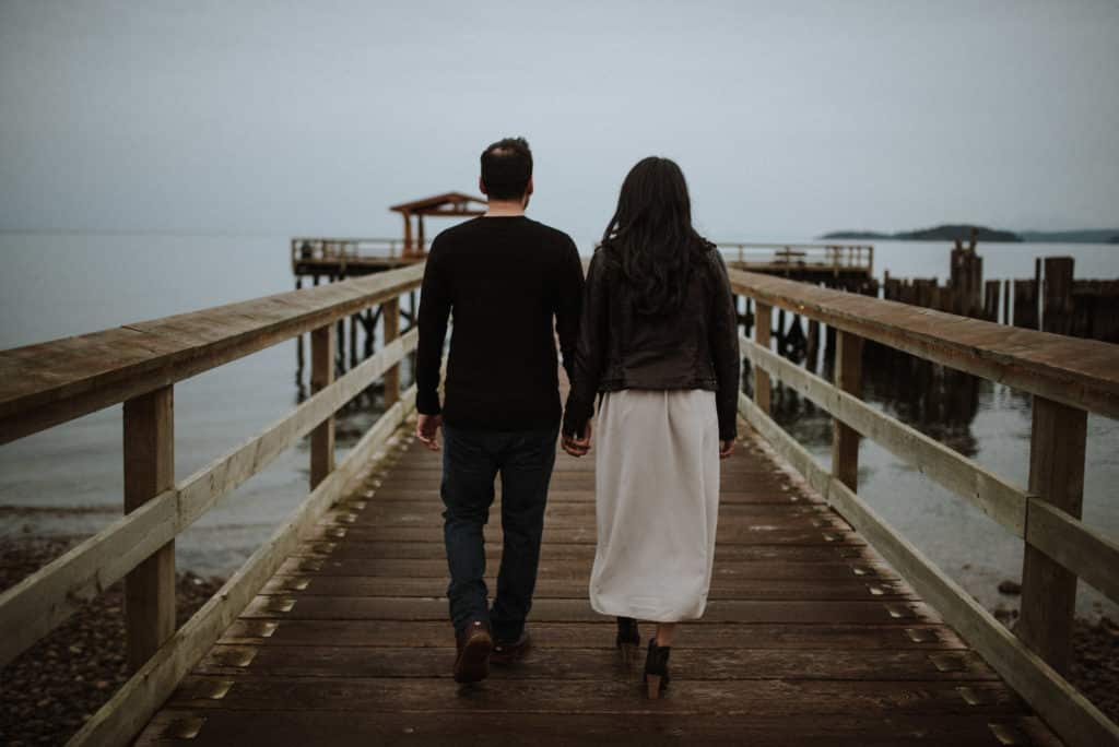 couple walk on the pier for an engagement session