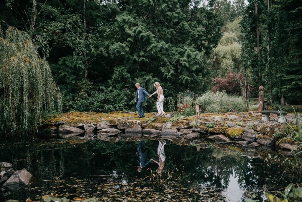 fresh air photography mentorships will help you tell a couple's wedding story like this image of a groom leading his new bride around a pond to exchange their vows