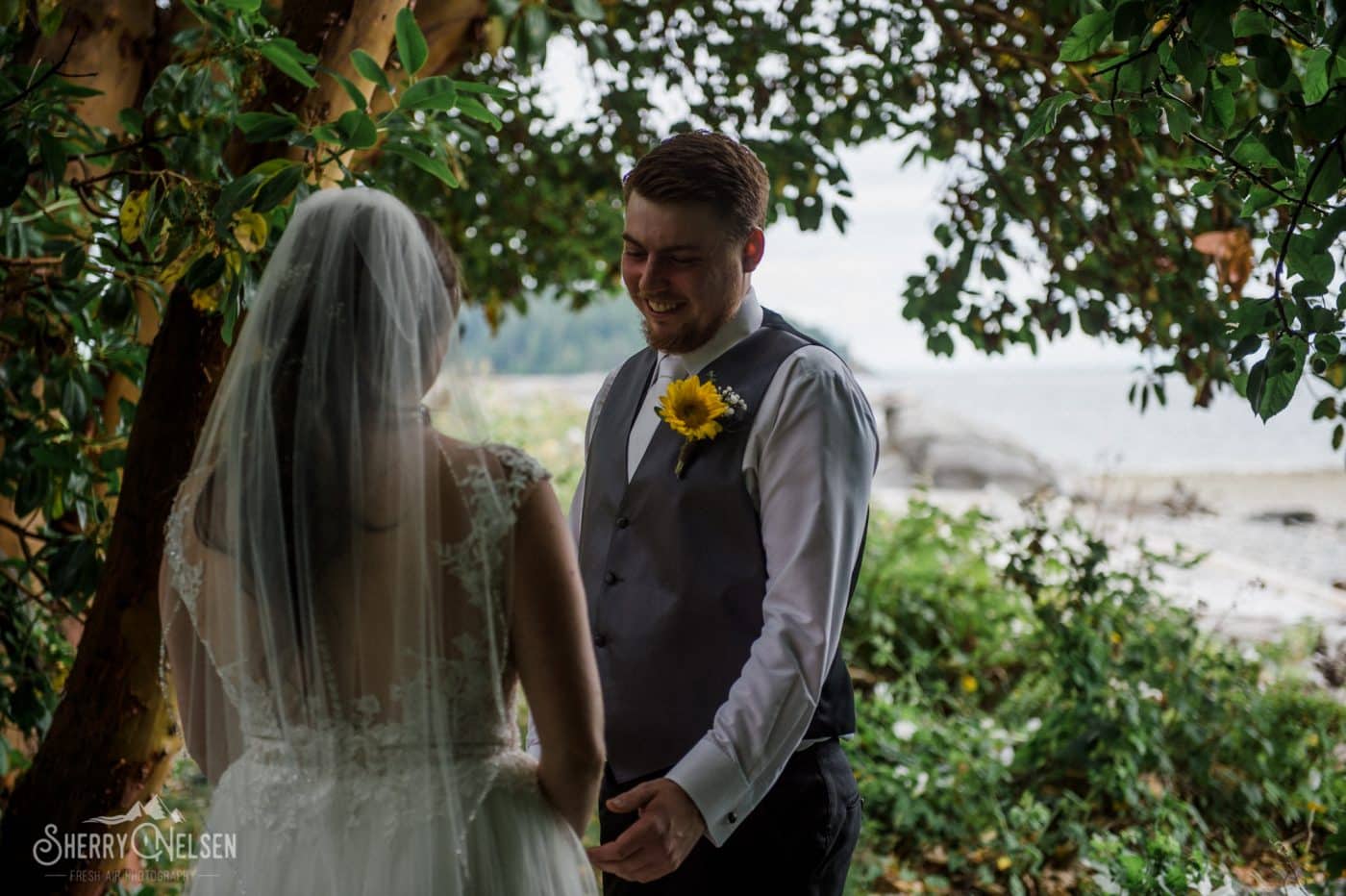the groom sees his bride for the first time dressed in white on the beach in West Sechelt, Sechelt BC