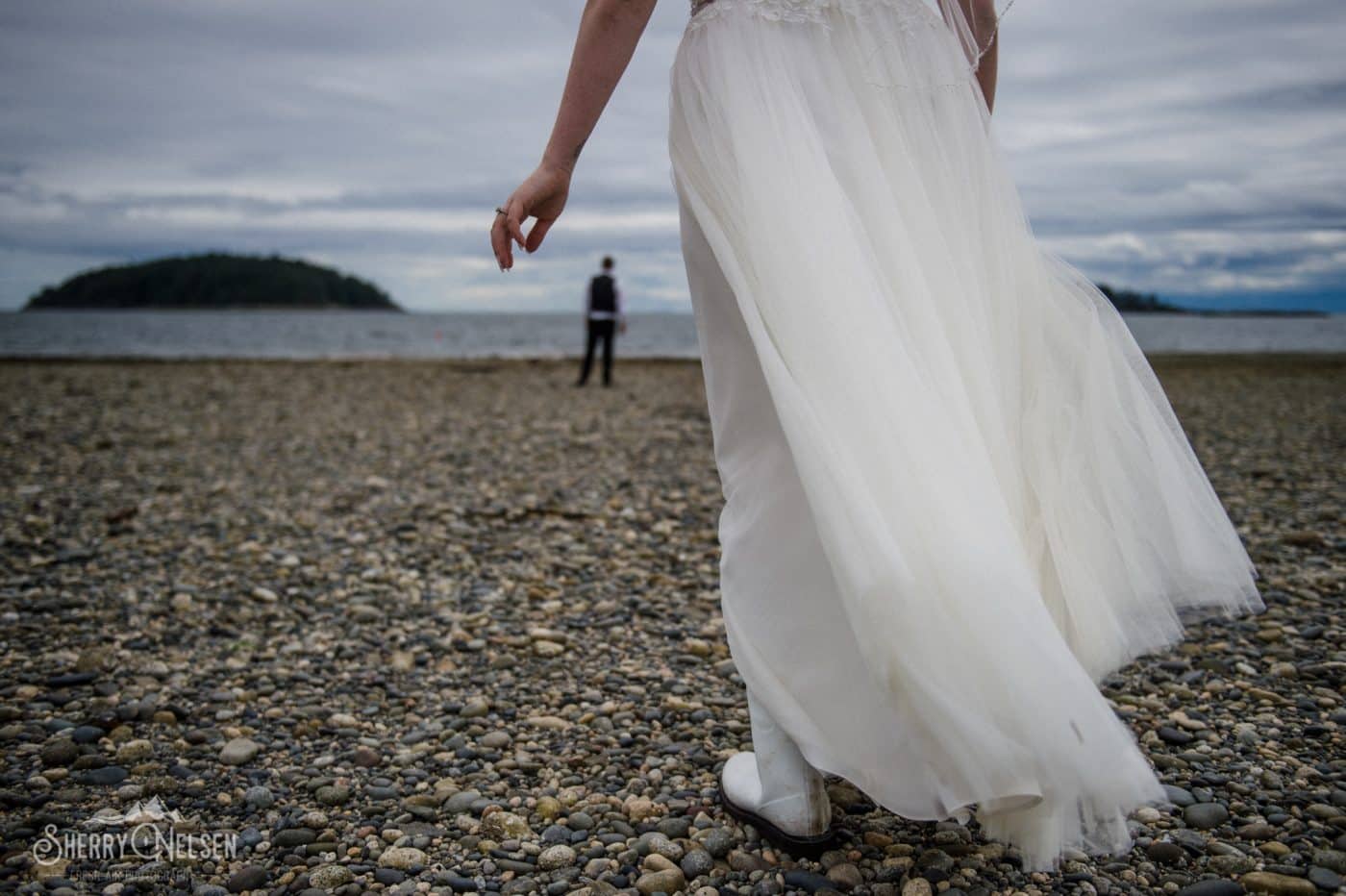 bride walking on the beach at low tide in her gum boots to meet with her groom West Sechelt BC