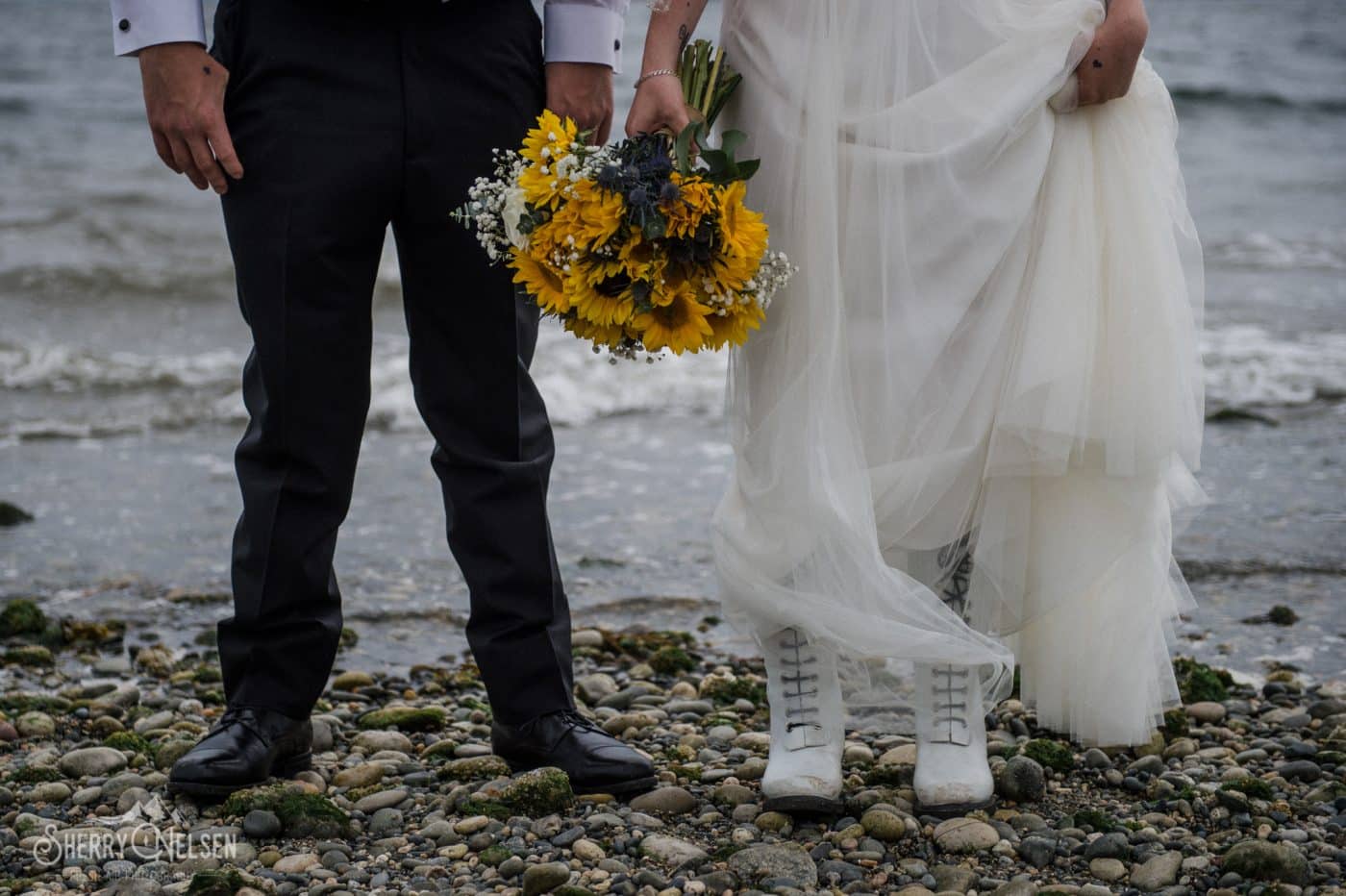 bride and groom pose with her gorgeous sunflower bouquet on the beach at Sechelt BC wedding