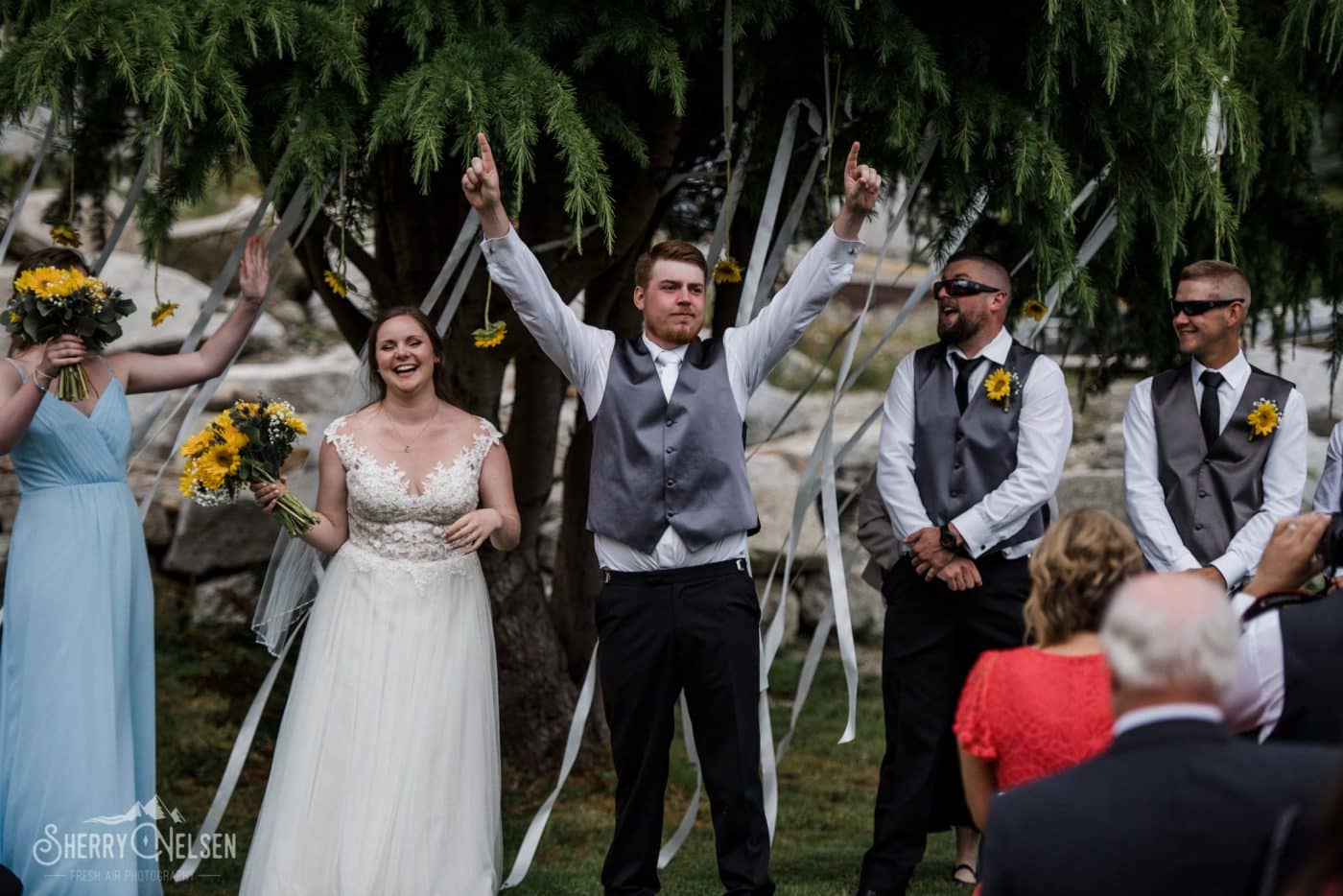 the groom holds his hands up as they are announced husband and wife at their Sechelt BC Wedding