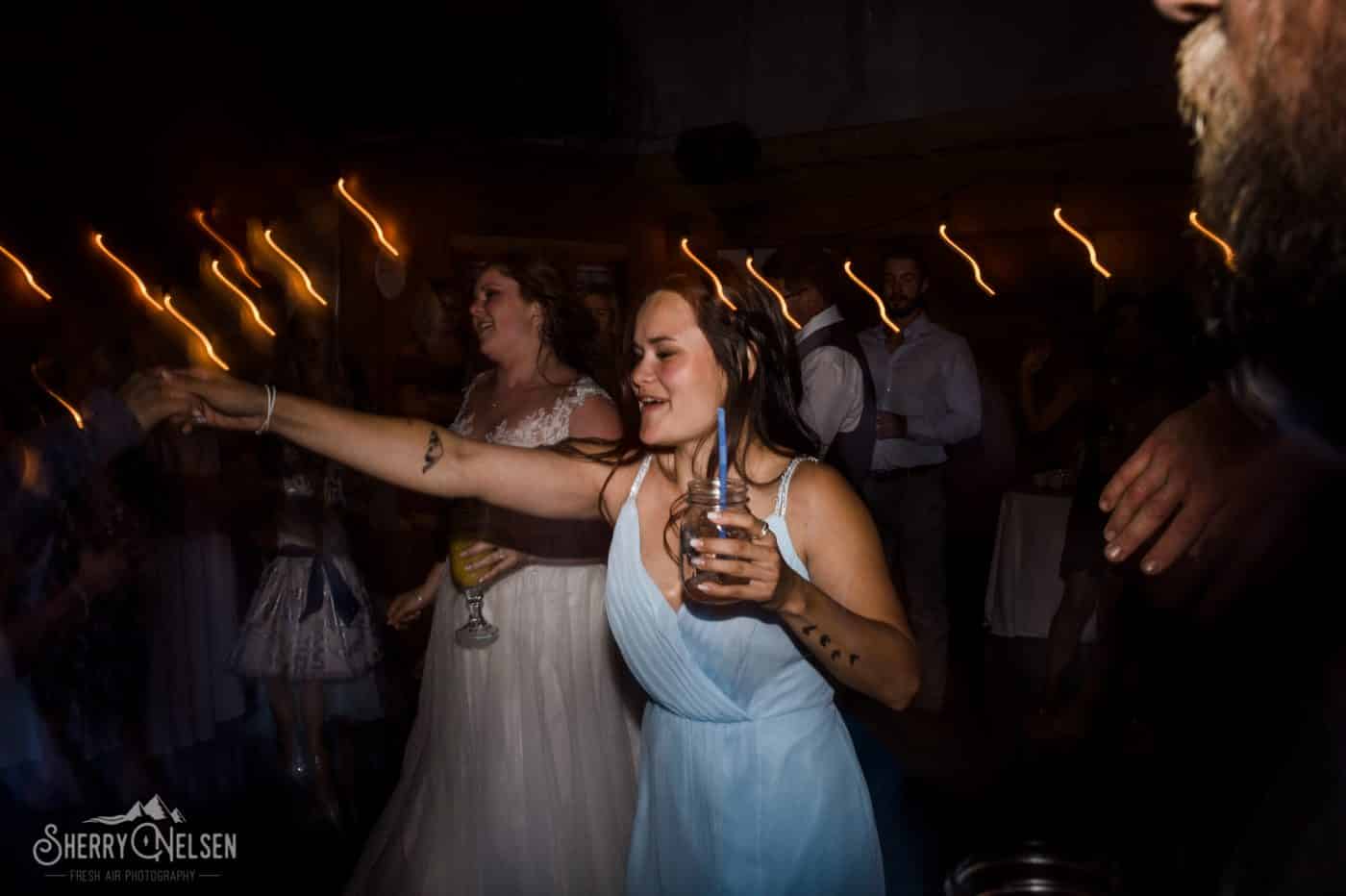 bride's sister having a drink and enjoying the party with party lights
