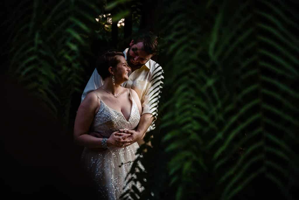 bride and groom between palm fronds in Bali