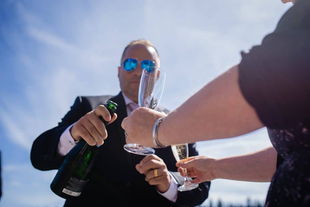 groom pours champagne after sunshine coast wedding ceremony