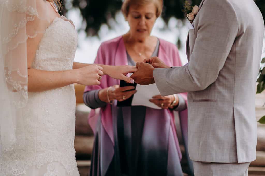 groom places the ring on the bride's finger at Sunshine Coast wedding