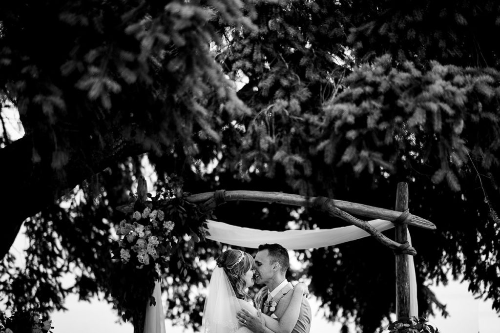black and white photo of husband kissing bride