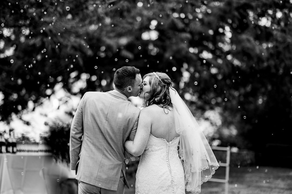 bride and groom kiss amongst bubbles