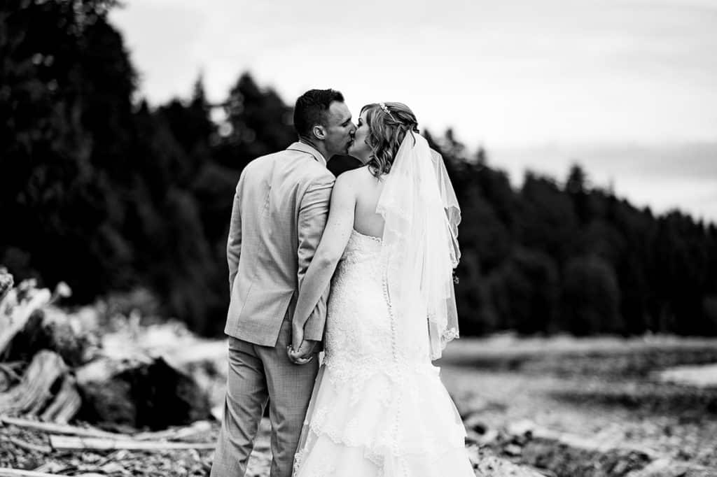 bride and groom steal a kiss on the beach at their Sunshine Coast BC wedding
