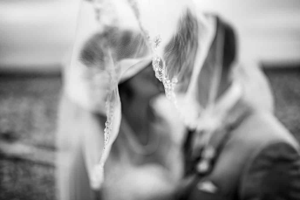 bride and groom kiss under the veil
