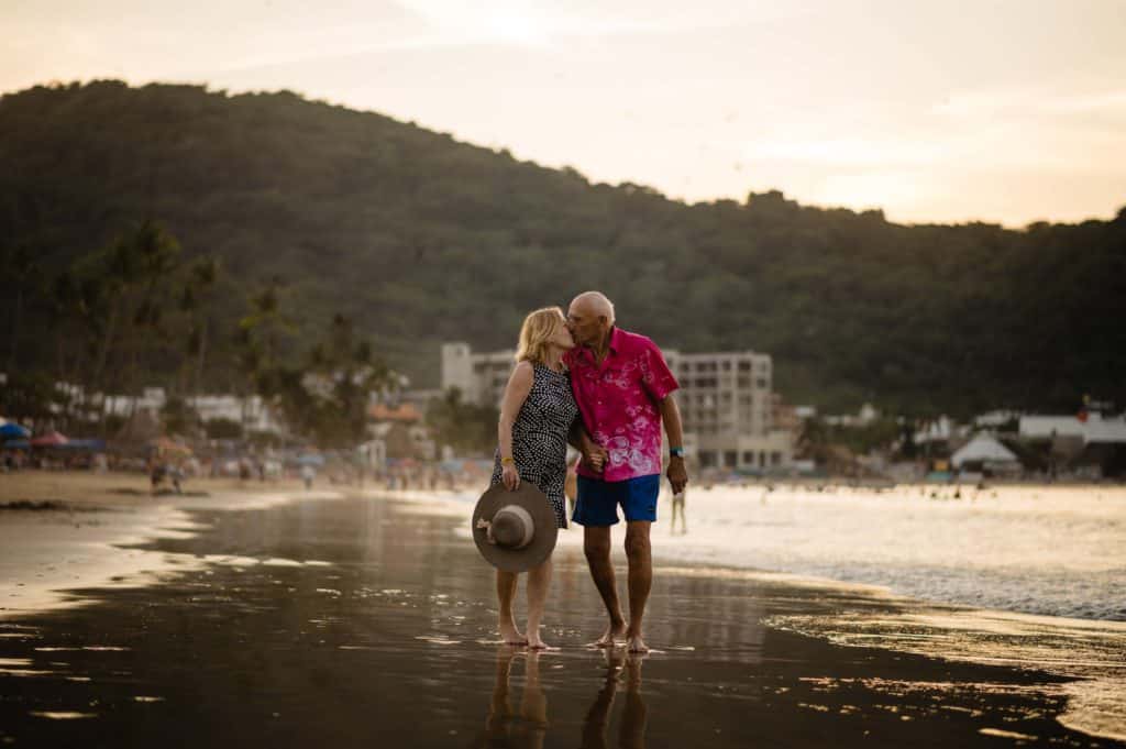 Anniversary story of a couple walking on the beach in Mexico and kissing