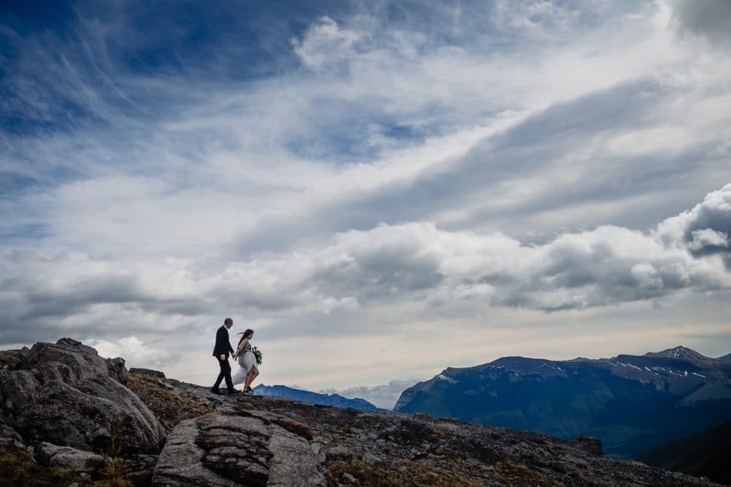 a newlywed couple walks on top of a mountain during their adventure elopement in british columbia with Fresh Air Photography