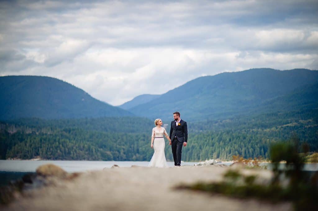 bride and groom walk along a deserted beach during their elopement on the sunshine coast of british columbia