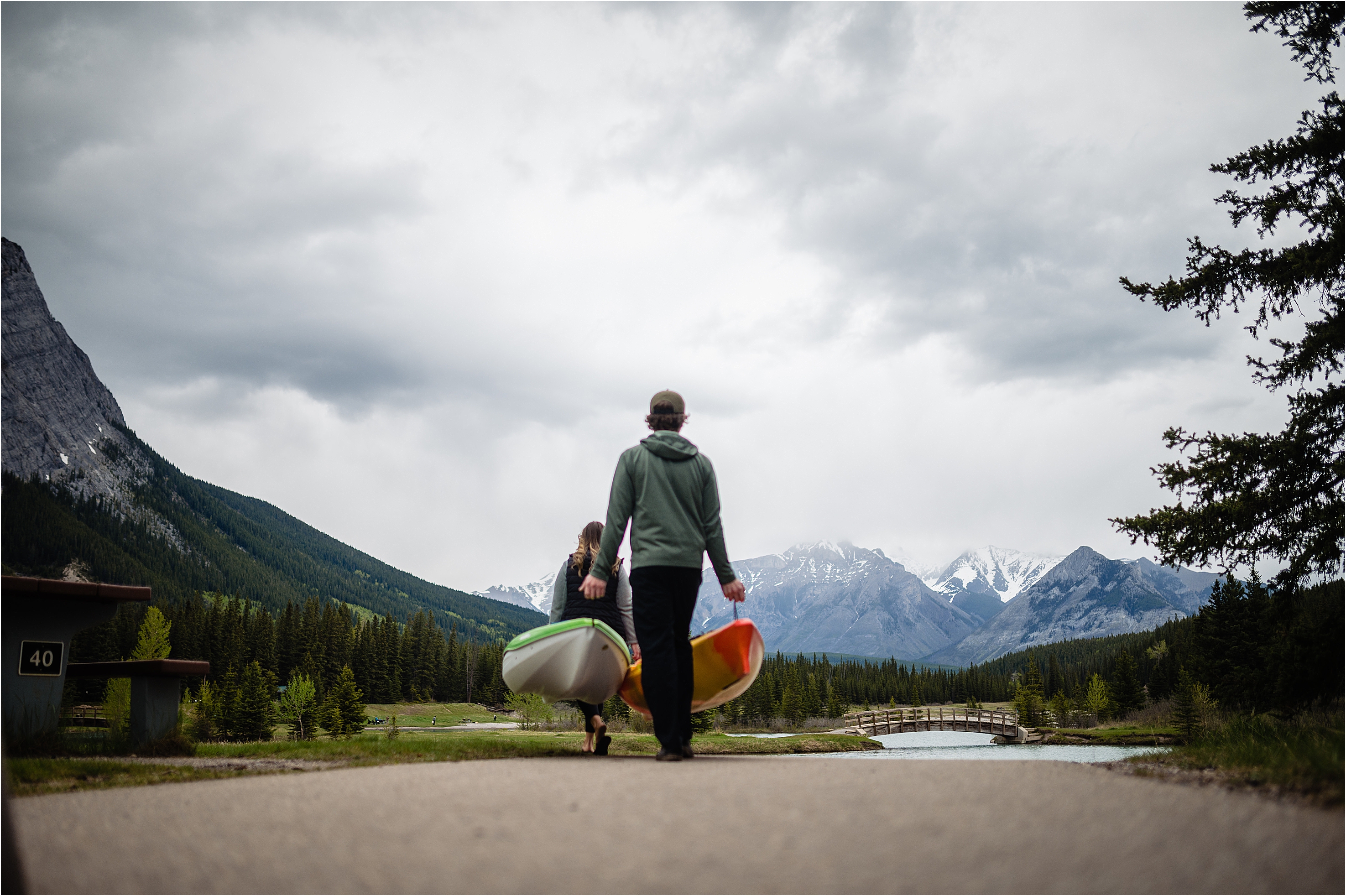 Banff adventure engagement photos of a couple carrying their kayak to the lake