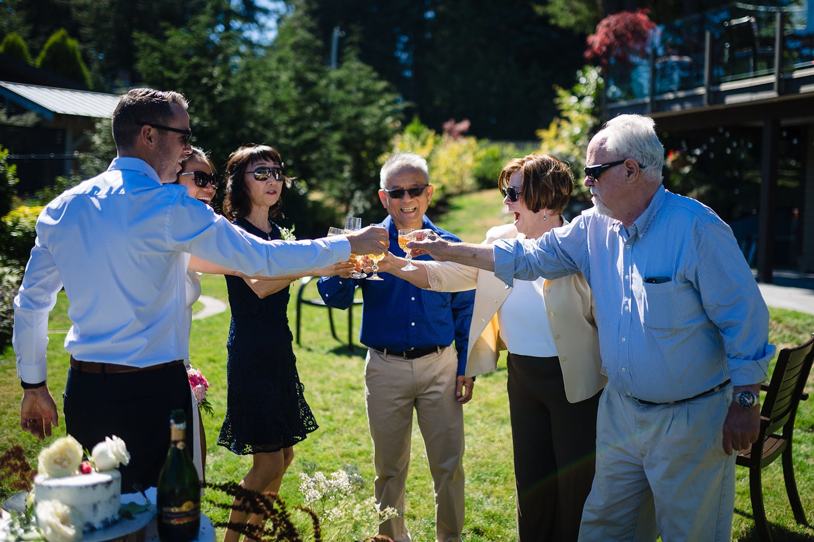 Mothers and Fathers of bride and groom hold glasses up for a toast in celebration of their children getting married in Halfmoon Bay