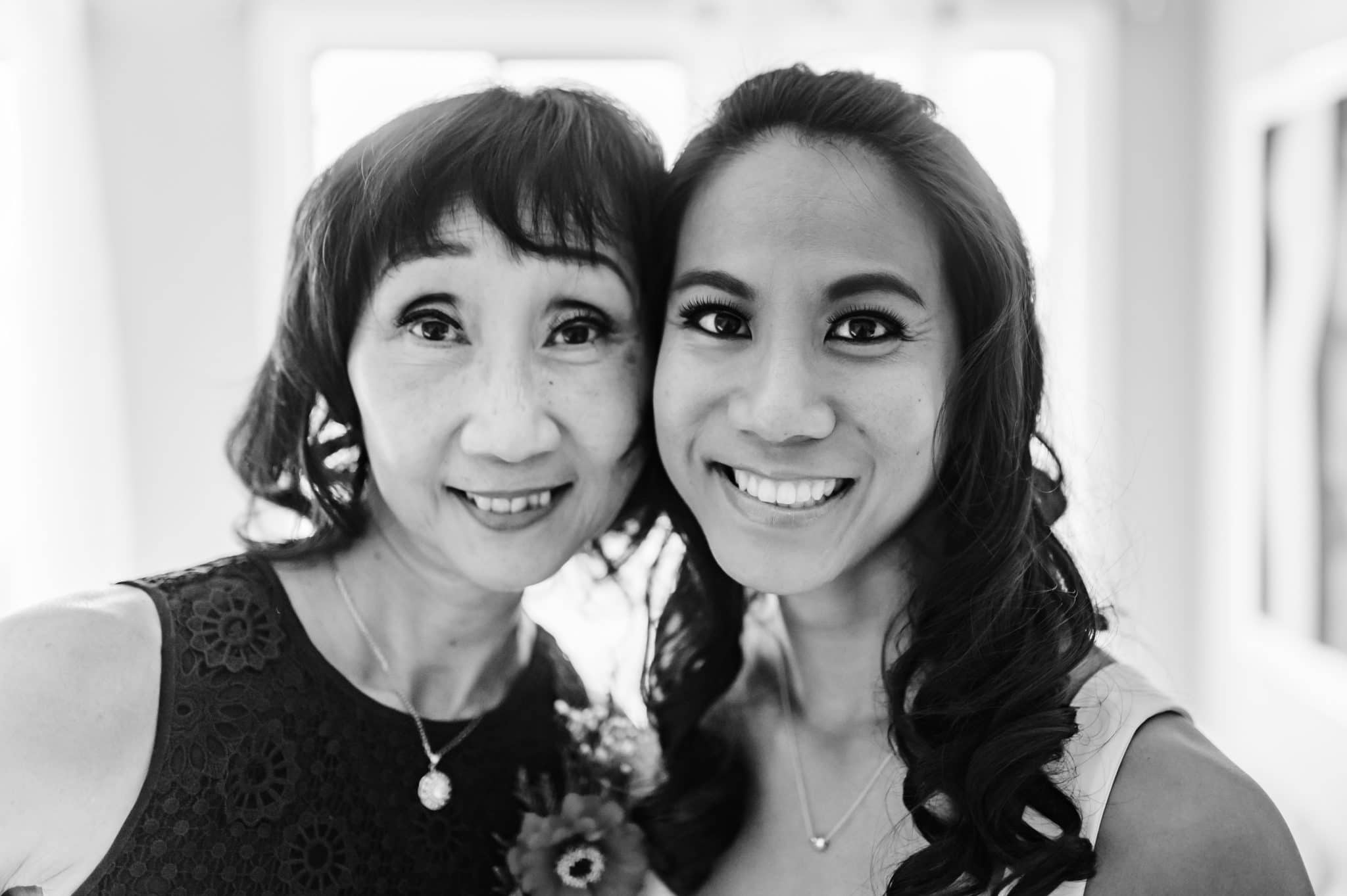 mother and daughter pose for a photo together before the bride goes to marry her man