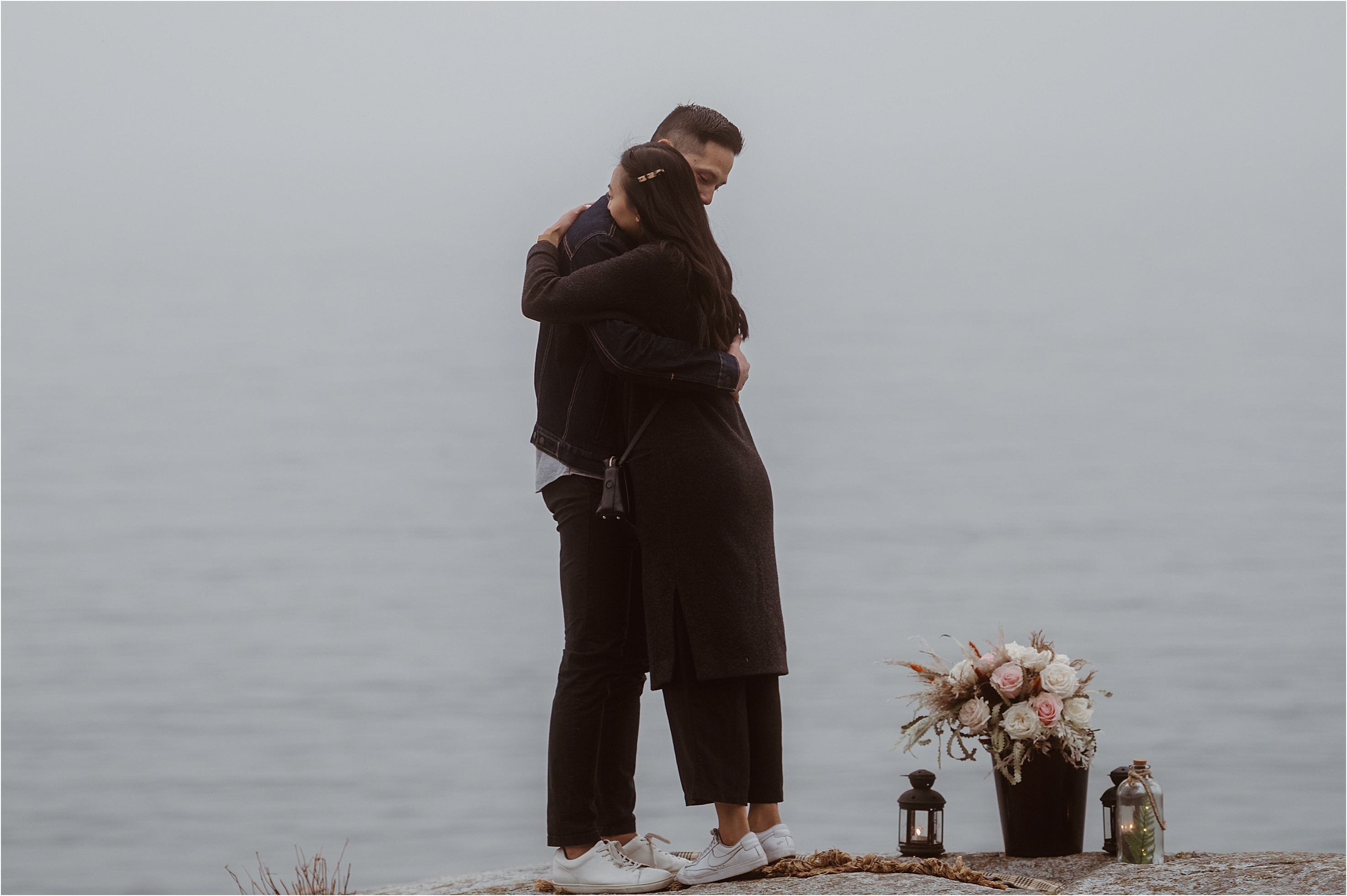 A young couple embrace just after he pops his surprise proposal. She said yes!