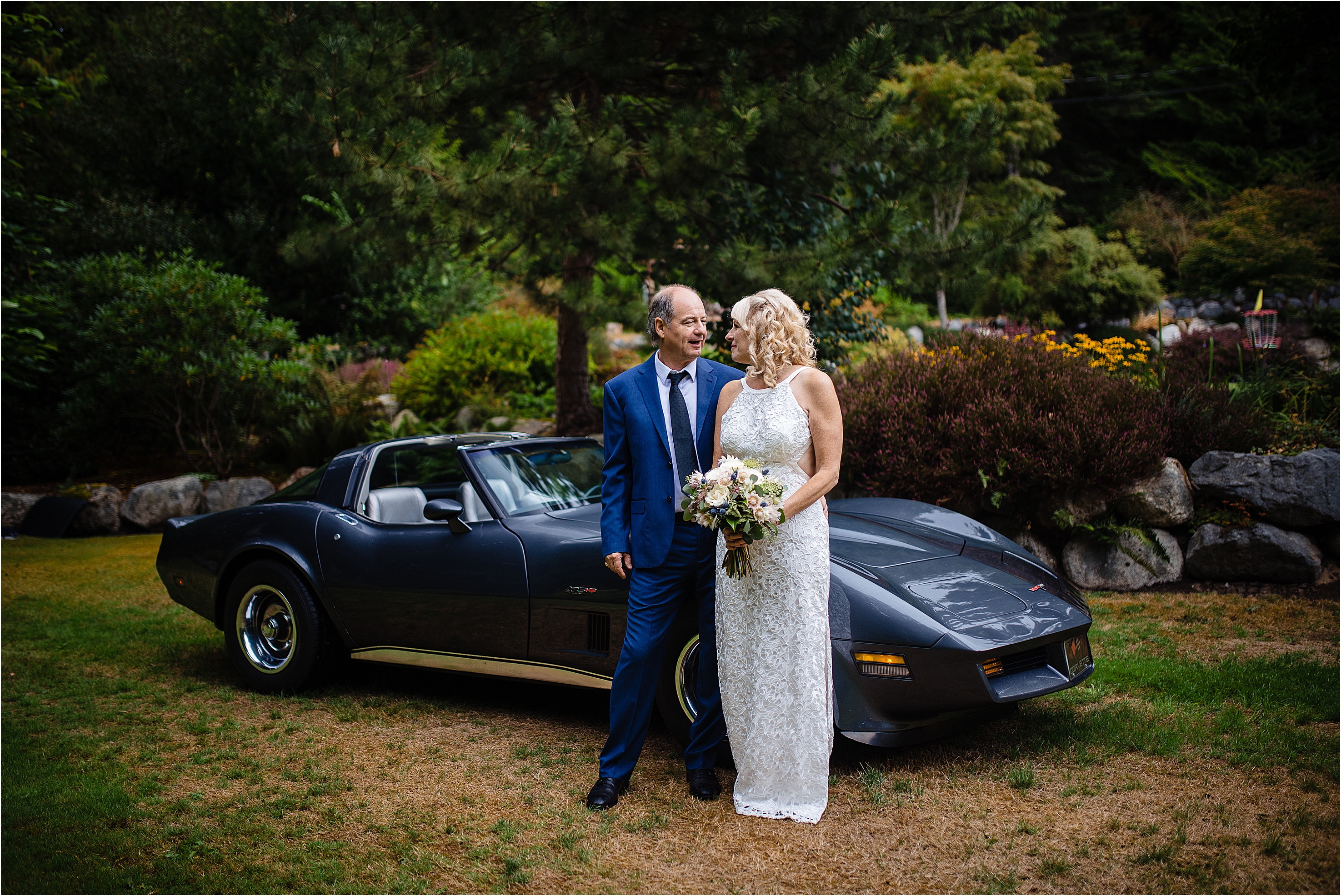 Bride and Groom stand in front of his prized 81 Corvette