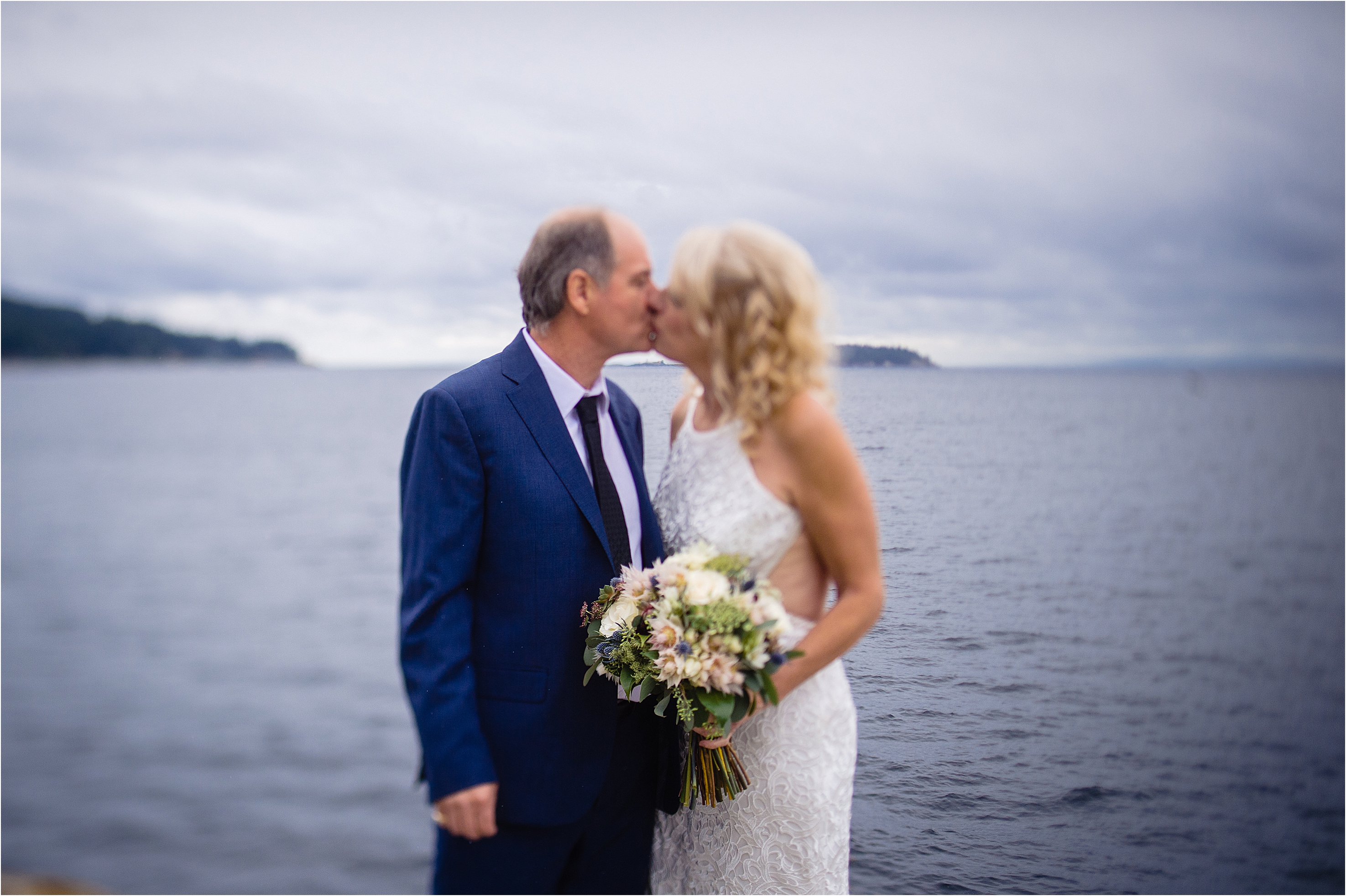 groom kisses his bride at halfmoon Bay