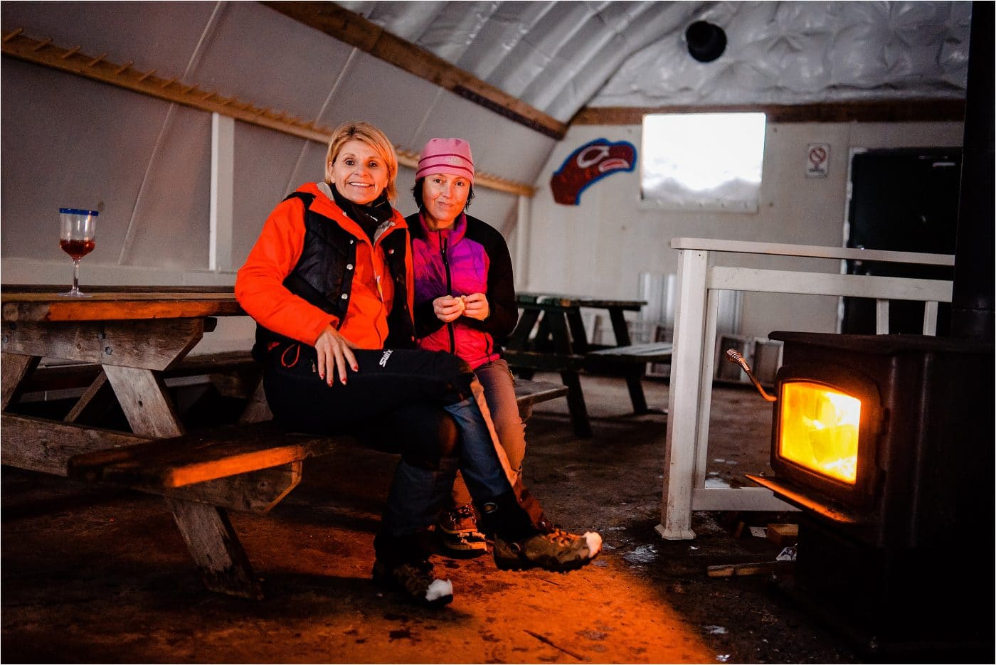 two friends warm at the fireside at Dakota Ridge