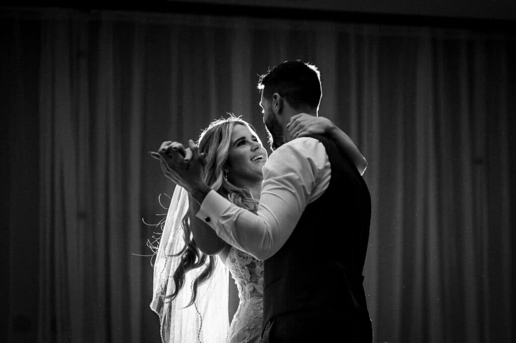A black and white photo of happy newlyweds dancing at their Sunshine Coast wedding reception