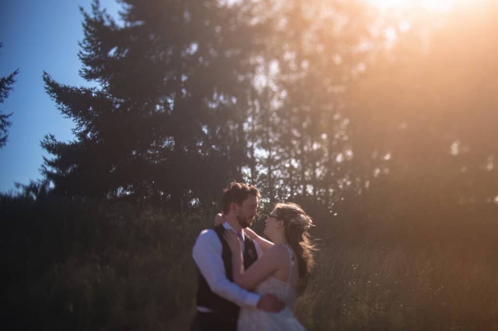 Bride and groom stand outside as captured by their Sunshine Coast wedding photographer admidst the trees